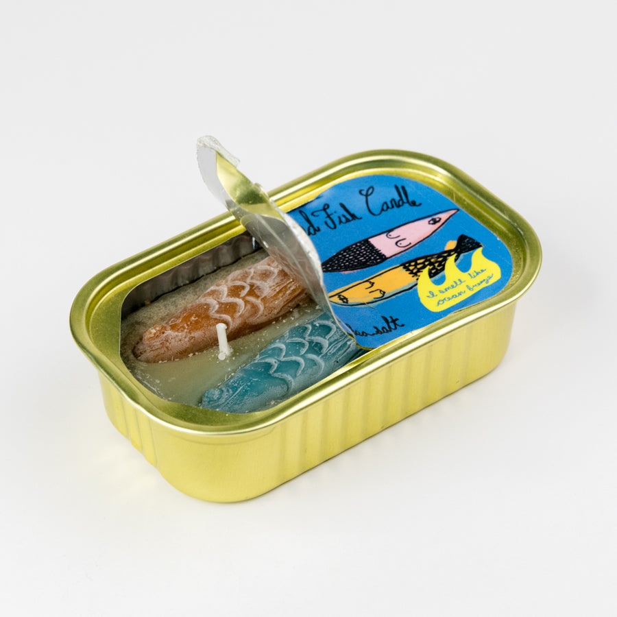 Sardine can-shaped candle with a decorative label on a white background