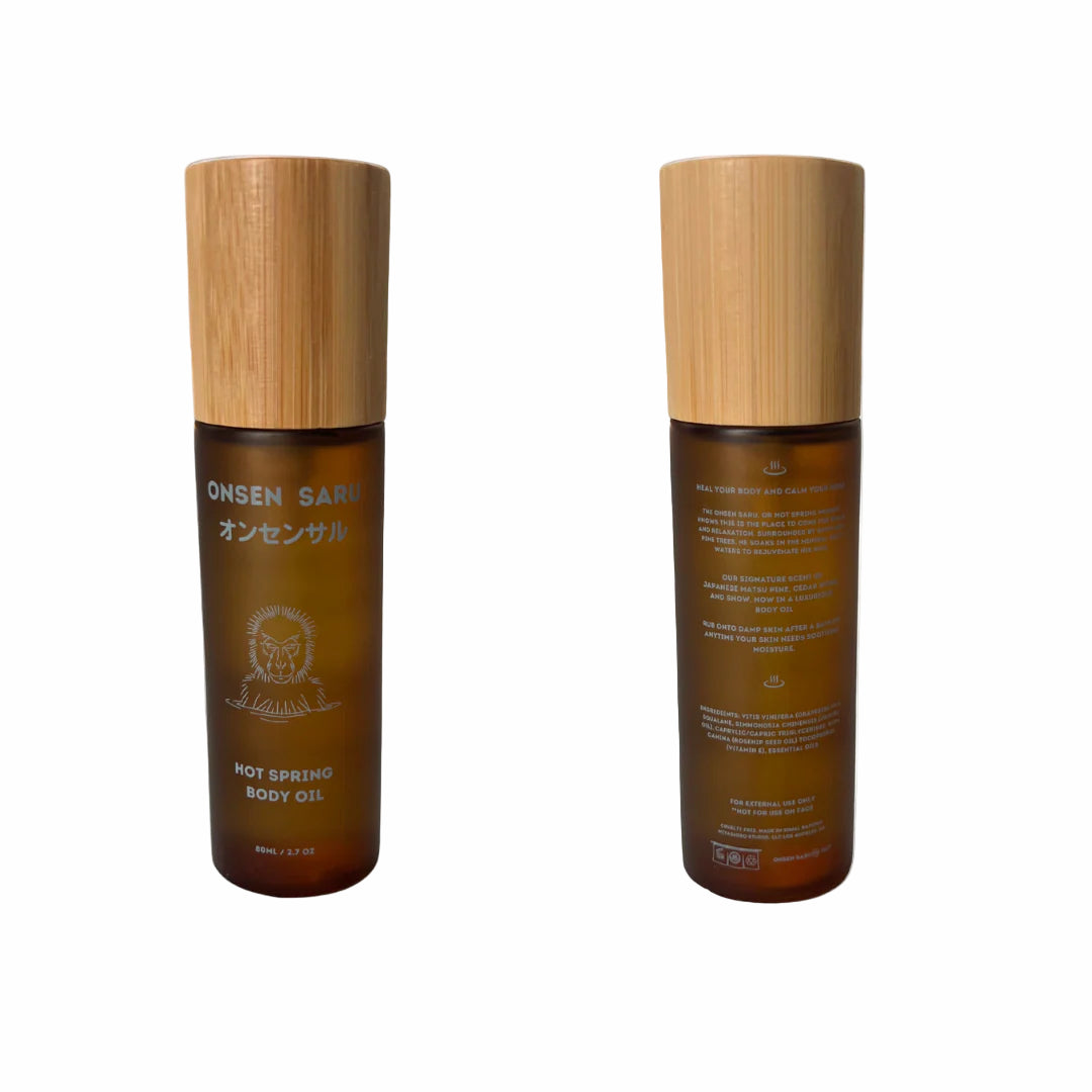 Two bottles of Onsen San hot spring body oil with wooden caps on a white background
