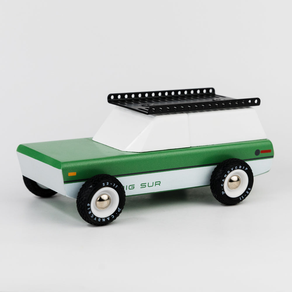 Toy truck with green body and white top on a light gray background