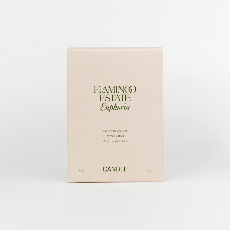 Beige candle box with 'Flamingo Estate Euphoria' text on a white background