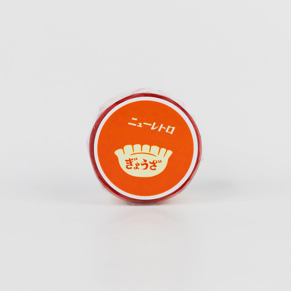 Small round container with an orange lid featuring Japanese text on a white background