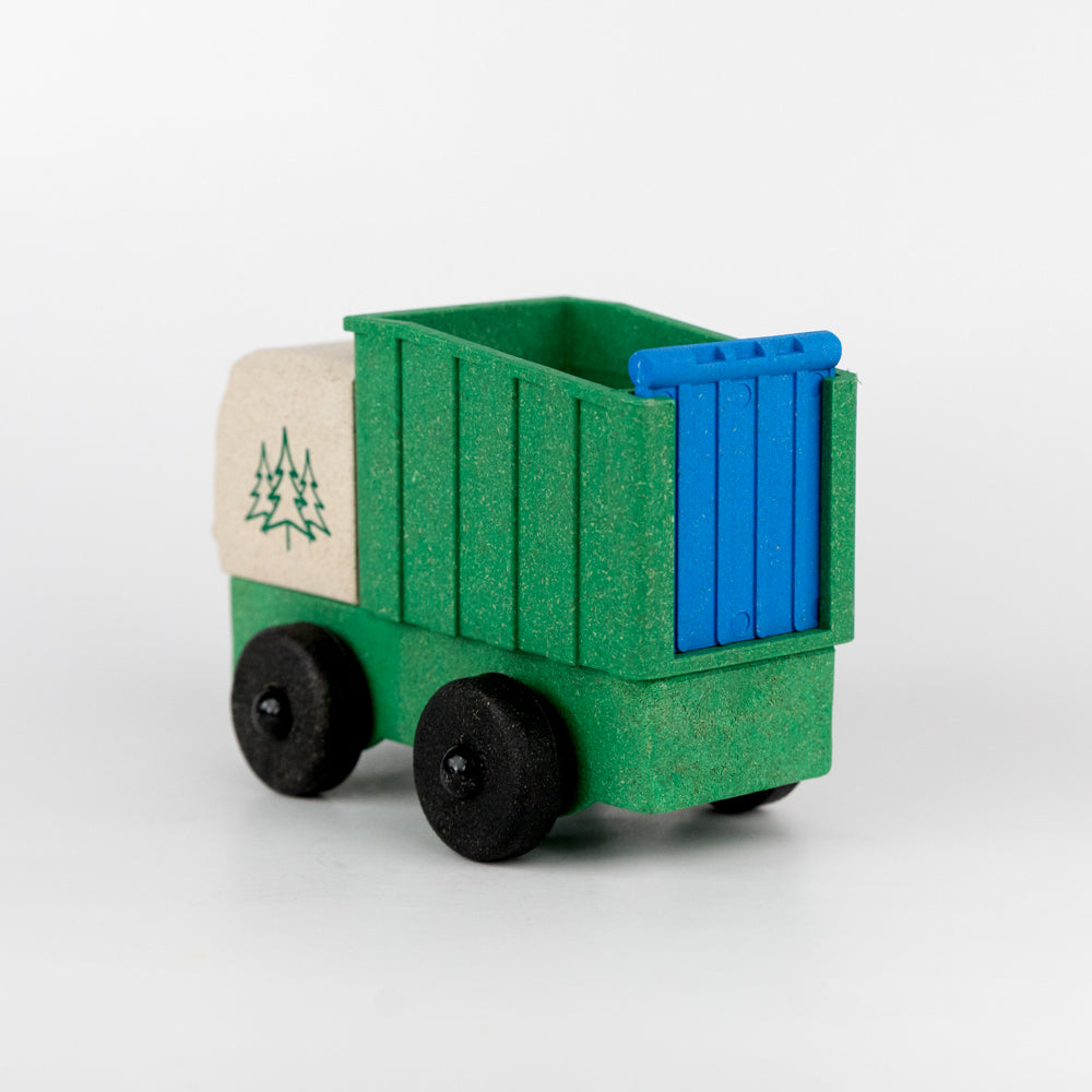 Toy truck with green body, blue back, and white front section on a light gray background