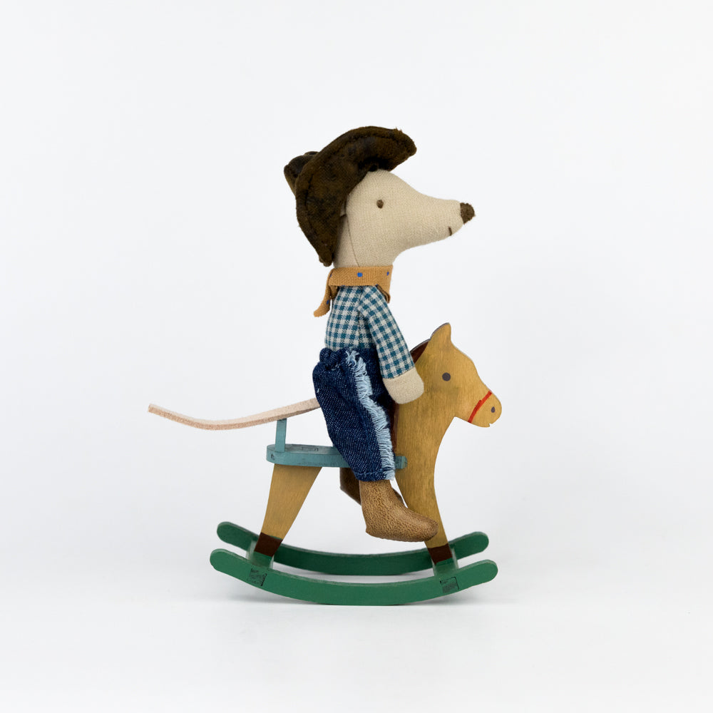 Toy mouse riding a rocking horse on a white background