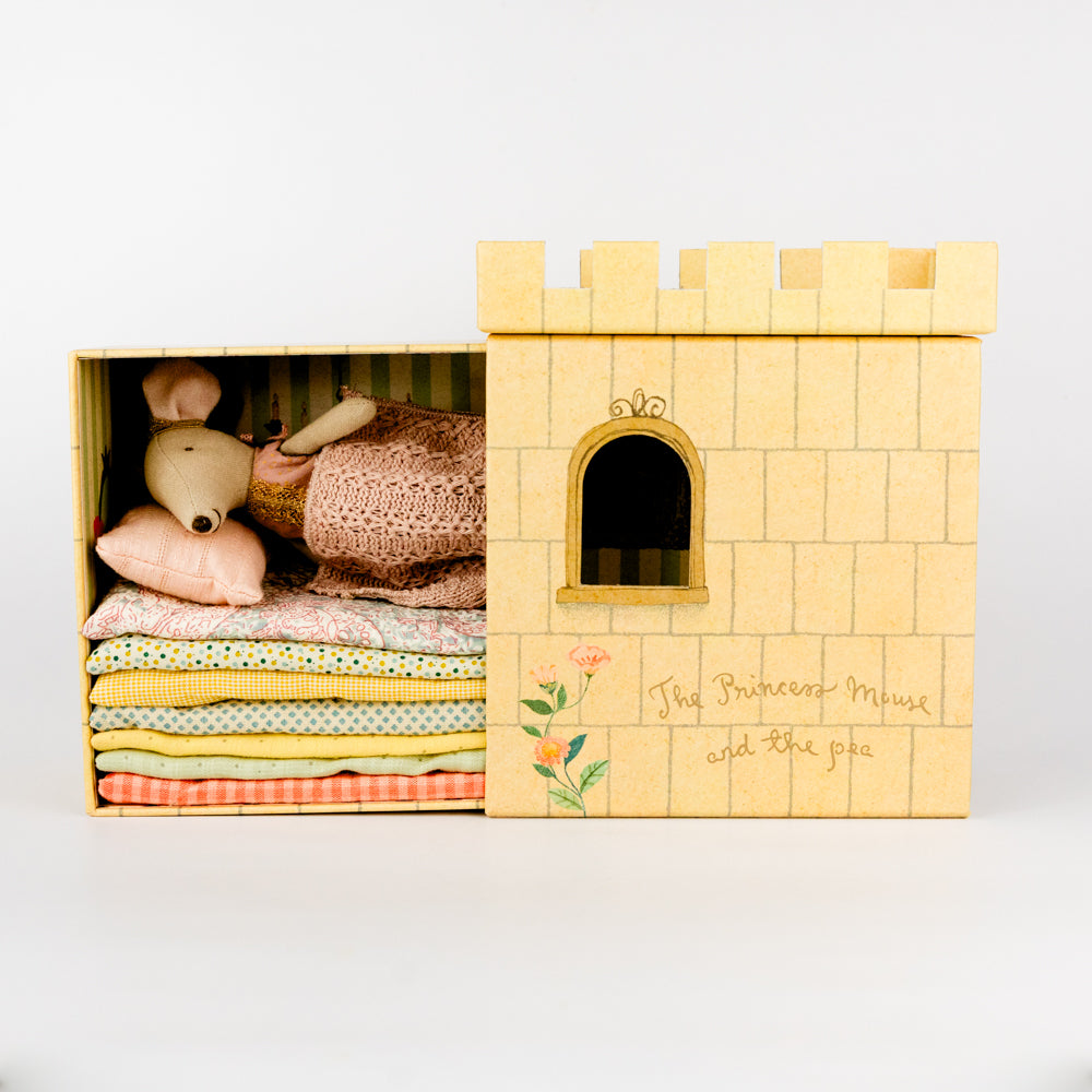 Toy castle with a mouse and fabric inside on a white background