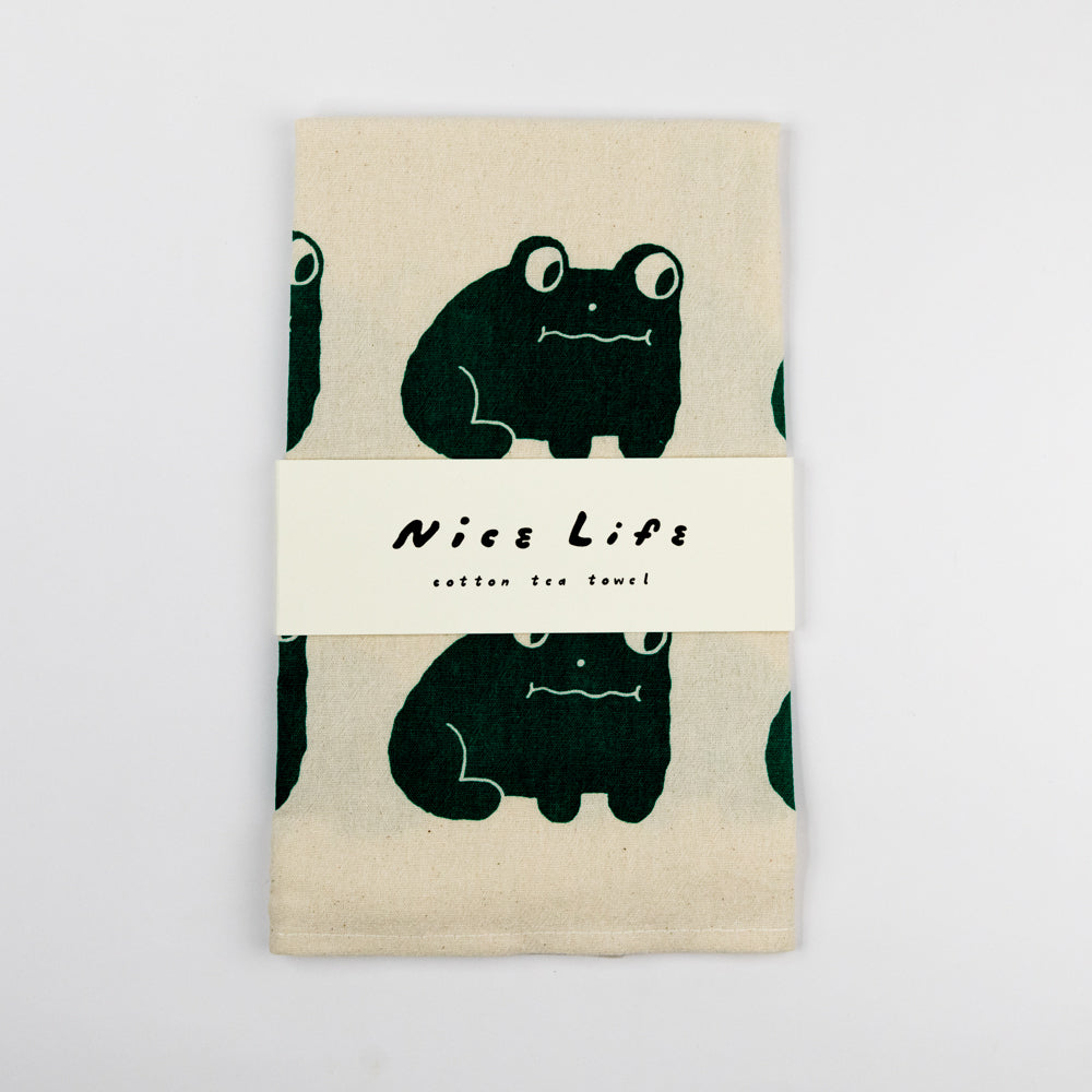Tea towel with black frog design and 'Nice Life' text on a beige background