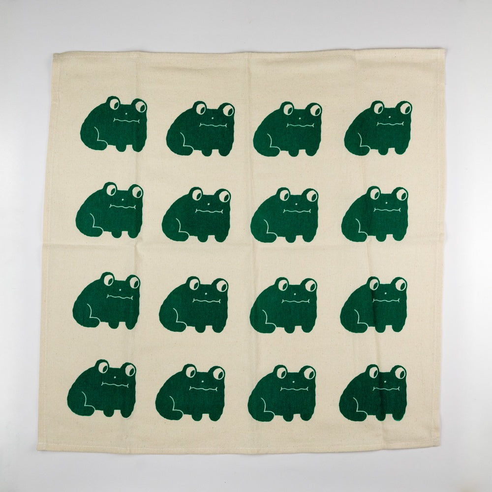 Beige towel with green frog pattern on a white background