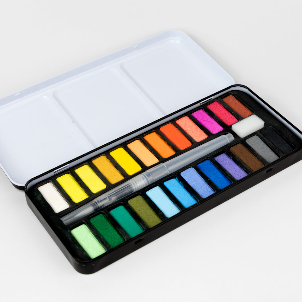 Watercolor paint set with a variety of colors on a light background